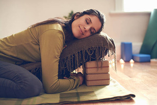 Serene lady relaxing and meditating on a yoga mat in a cosy house